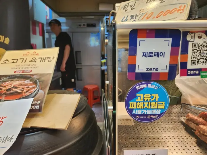 떡갈비 매장 입구에 부착된 '고유가 피해지원금 사용 가능' 스티커. 사장은 지원금 이후 평소 지나치던 손님들이 가게를 찾기 시작했다고 말했다.
